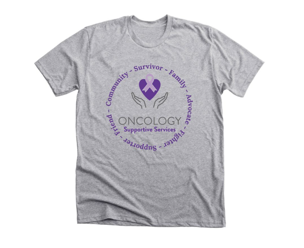 A grey t-shirt with the Oncology Supportive Services logo on it in purple. 